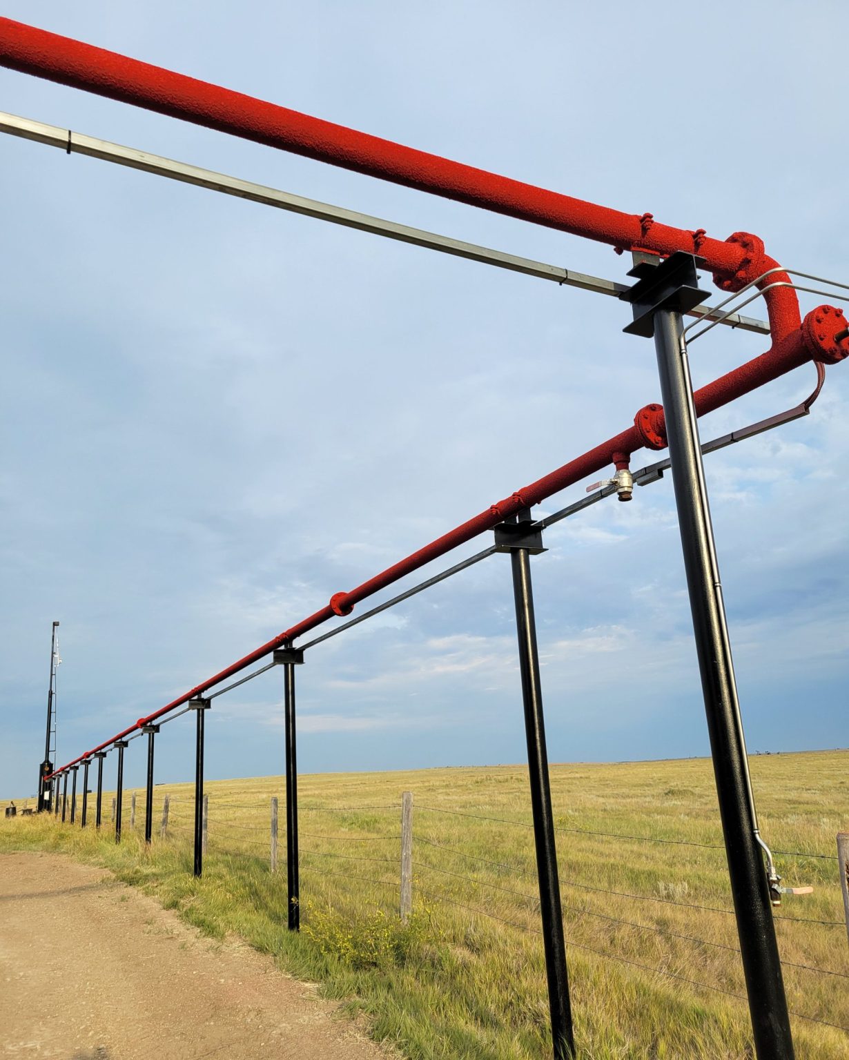 Red Thermal CorkShield on above-ground piping on oil site in Saskatchewan.